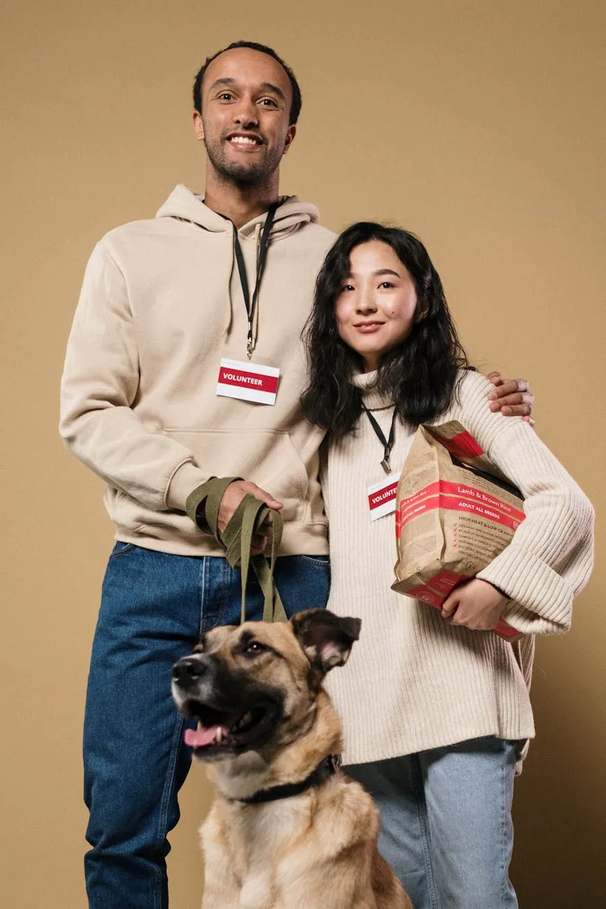 Two smiling volunteers wearing name badges, standing with a dog